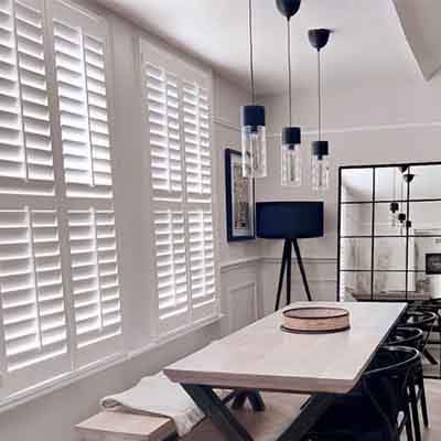 Tier on tier window shutters installed in a dining room.