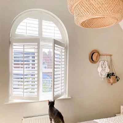 Custom shape window shutters installed in an awkward shaped window.